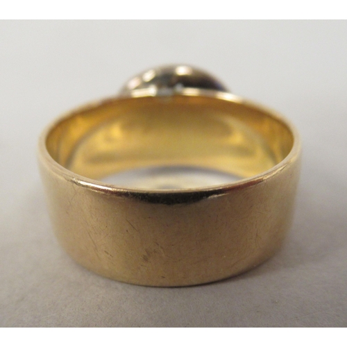 38 - An 18ct gold band ring, surmounted by a flowerhead