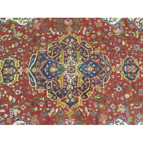 381 - An Isfahan rug, profusely decorated with repeating stylised designs, on a multi-coloured ground ... 