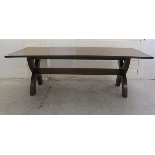 383 - A Stuart Linford stained oak dining table, the solid top raised on a pair of cross frame legs, unite... 