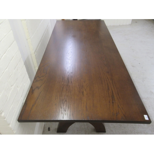 383 - A Stuart Linford stained oak dining table, the solid top raised on a pair of cross frame legs, unite... 