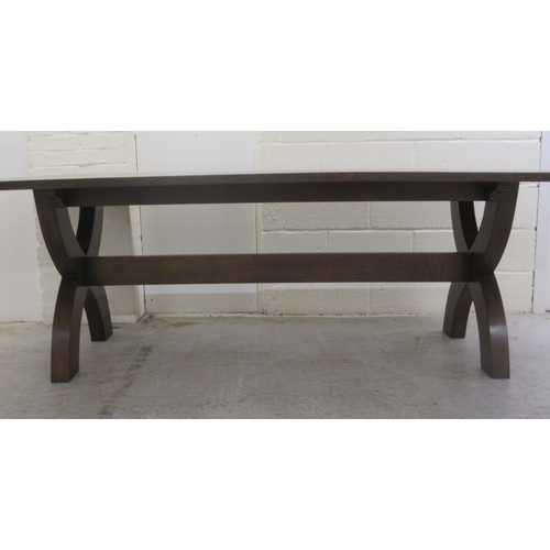 383 - A Stuart Linford stained oak dining table, the solid top raised on a pair of cross frame legs, unite... 