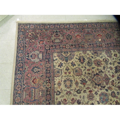 402 - A Persian carpet, profusely decorated with vases, flora and foliage, on a multi-coloured ground ... 