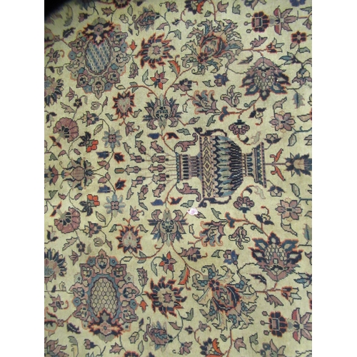 402 - A Persian carpet, profusely decorated with vases, flora and foliage, on a multi-coloured ground ... 