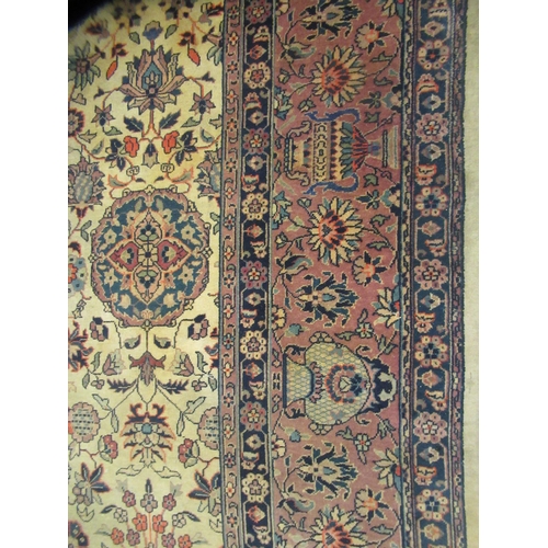 402 - A Persian carpet, profusely decorated with vases, flora and foliage, on a multi-coloured ground ... 