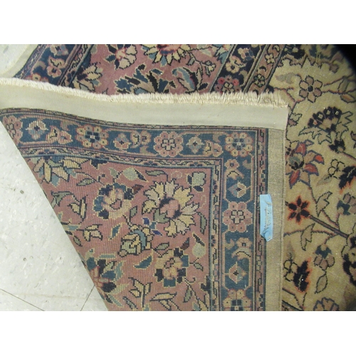 402 - A Persian carpet, profusely decorated with vases, flora and foliage, on a multi-coloured ground ... 