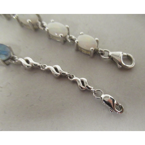 57 - Two silver coloured metal bracelets, variously claw set with coloured stones 