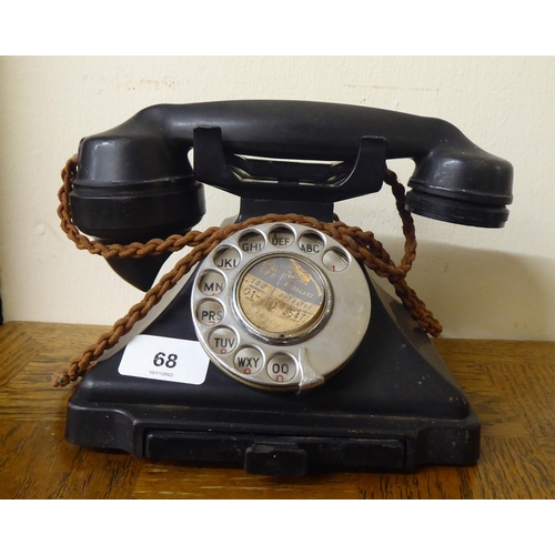 68 - A vintage black bakelite cased telephone instrument with a rotating dial, cradle and address drawer&... 