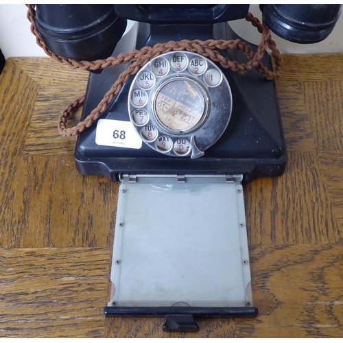 68 - A vintage black bakelite cased telephone instrument with a rotating dial, cradle and address drawer&... 