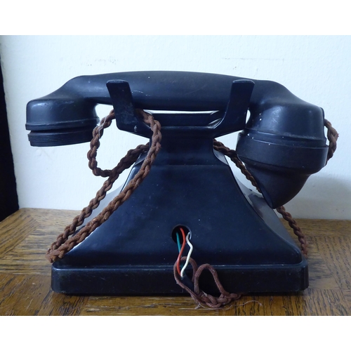 68 - A vintage black bakelite cased telephone instrument with a rotating dial, cradle and address drawer&... 