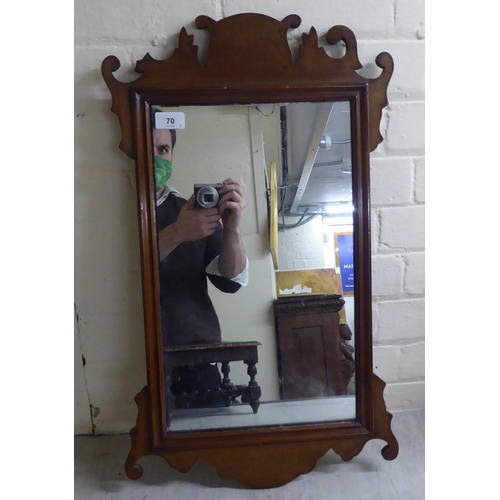 70 - An early 20thC Chippendale inspired, mahogany framed mirror with a fretworked border  25