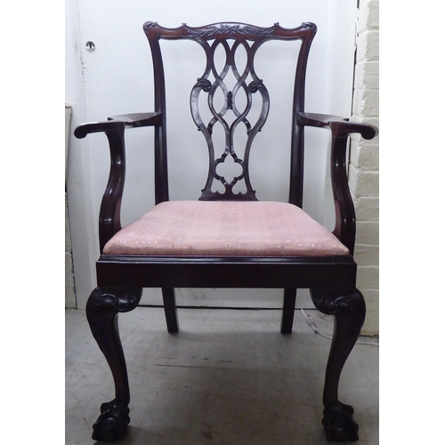 91 - A 1930s mahogany showwood framed Chippendale design pierced and carved splat back open arm chair, th... 