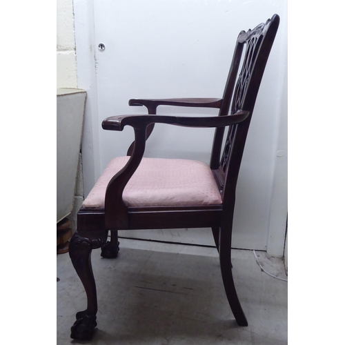 91 - A 1930s mahogany showwood framed Chippendale design pierced and carved splat back open arm chair, th... 