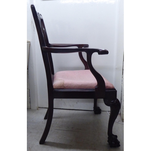 91 - A 1930s mahogany showwood framed Chippendale design pierced and carved splat back open arm chair, th... 