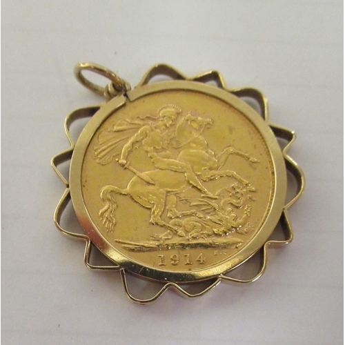 346 - A George V sovereign, St George on the obverse  1914, in a yellow metal pendant frame, together with... 