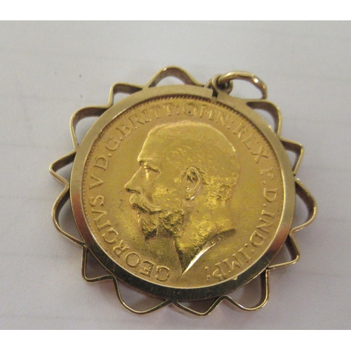 346 - A George V sovereign, St George on the obverse  1914, in a yellow metal pendant frame, together with... 