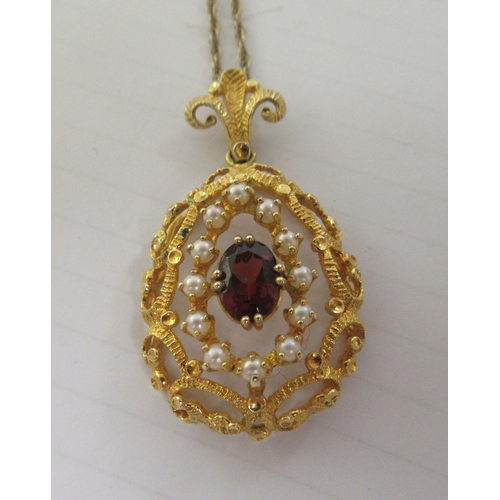 347 - A 9ct textured gold peardrop shaped pendant, set with a coloured stone and seed pearls, on a fine ye... 