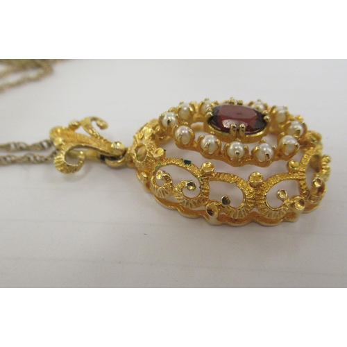 347 - A 9ct textured gold peardrop shaped pendant, set with a coloured stone and seed pearls, on a fine ye... 