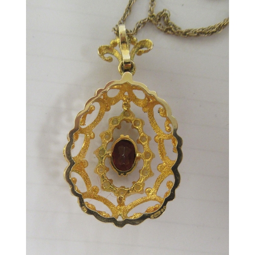 347 - A 9ct textured gold peardrop shaped pendant, set with a coloured stone and seed pearls, on a fine ye... 