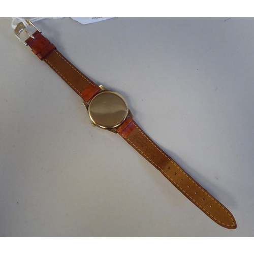 11 - A Longines 9ct gold cased wristwatch, faced by an Arabic and baton dial, on a stitched mid brown hid... 