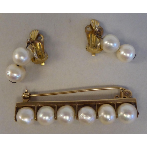 126 - A gold coloured metal bar brooch, set with six inline pearls; and a pair of twin bead pearl drop cli... 