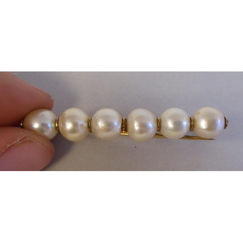 126 - A gold coloured metal bar brooch, set with six inline pearls; and a pair of twin bead pearl drop cli... 