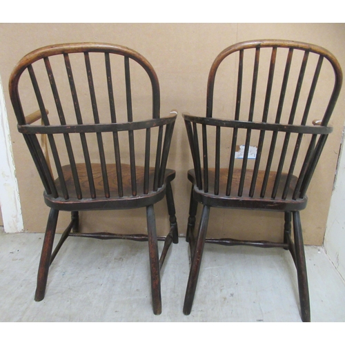 132 - A matched pair of early 19thC beech and elm framed low hoop and spindled back Windsor elbow chairs, ... 