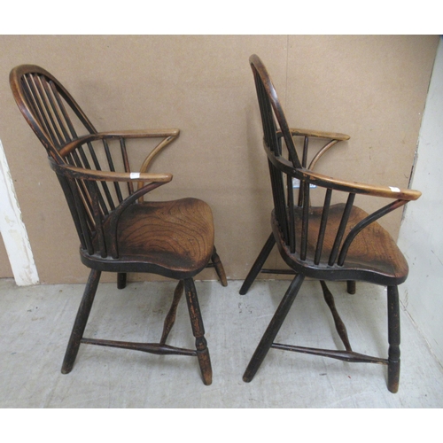 132 - A matched pair of early 19thC beech and elm framed low hoop and spindled back Windsor elbow chairs, ... 