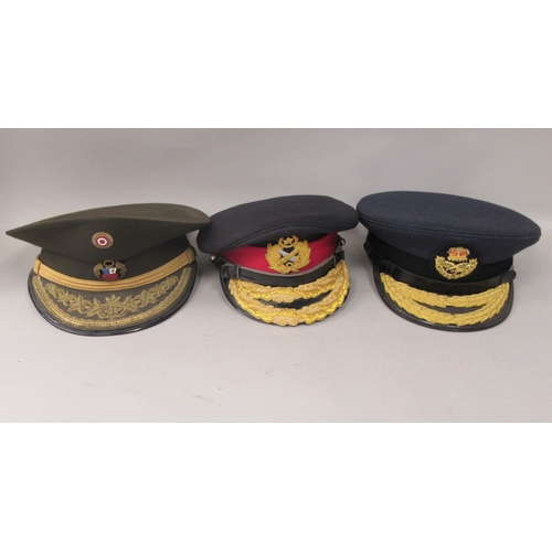 148 - Nine various unidentified foreign military officers' peaked uniform hats, decorated with emblems and... 