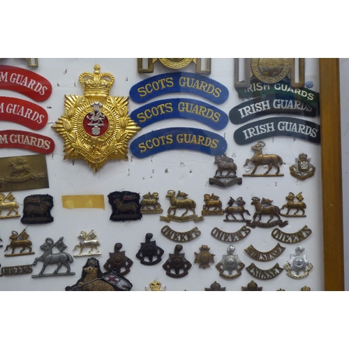 15 - Over seventy military cap badges and other insignia, embroidered uniform identification badges and b... 