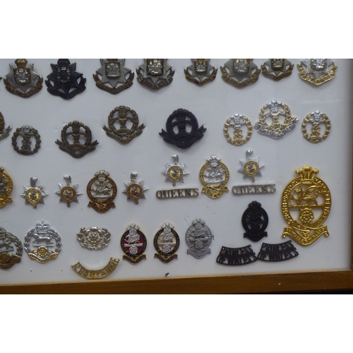 15 - Over seventy military cap badges and other insignia, embroidered uniform identification badges and b... 