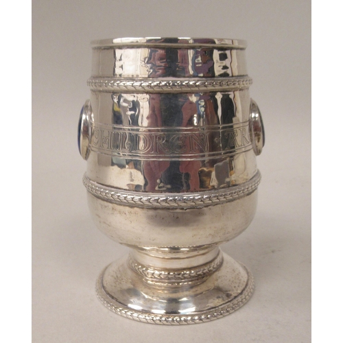 155 - A silver Christening pedestal mug of tapered cylindrical form with an angular handle, an applied cas... 