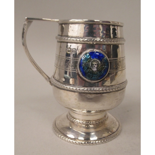 155 - A silver Christening pedestal mug of tapered cylindrical form with an angular handle, an applied cas... 