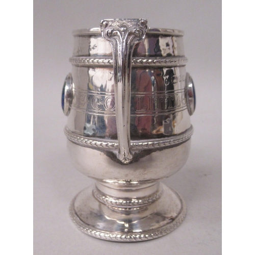 155 - A silver Christening pedestal mug of tapered cylindrical form with an angular handle, an applied cas... 