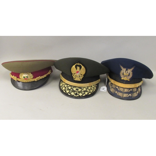 183 - Eight various foreign military officers' peaked uniform hats, decorated with emblems and braid: to i... 