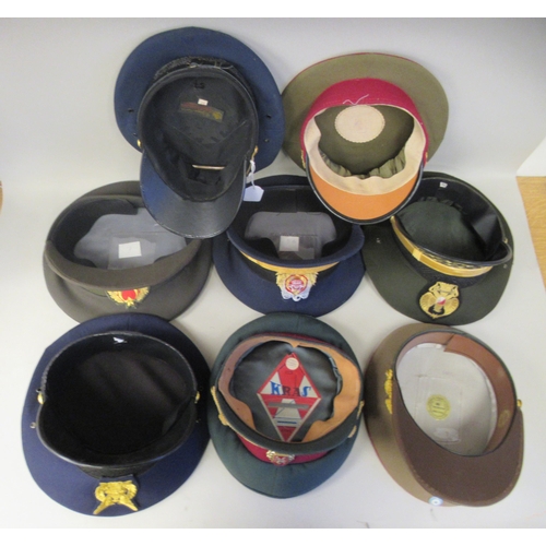 183 - Eight various foreign military officers' peaked uniform hats, decorated with emblems and braid: to i... 