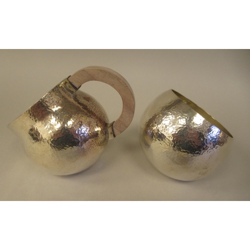 21 - An Art Deco inspired three piece spot-hammered silver tea set of spherical form  comprising a teapot... 