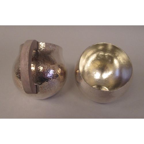 21 - An Art Deco inspired three piece spot-hammered silver tea set of spherical form  comprising a teapot... 