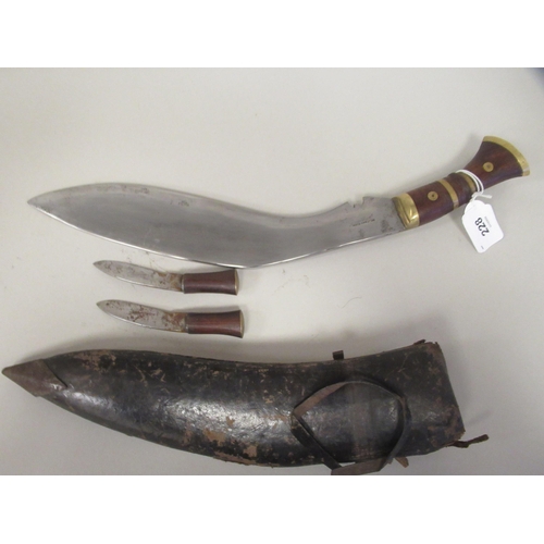 228 - An Asian Kukri with a brass mounted hardwood handle  the blade 12