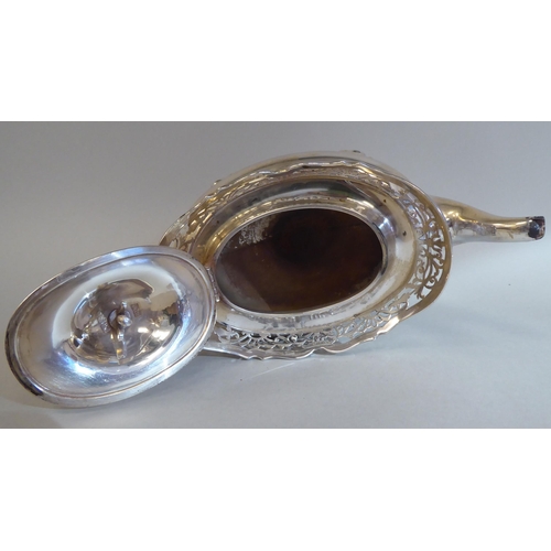 23 - A three piece silver tea set of oval, bulbous form with angled, pierced upstand rims, comprising a t... 