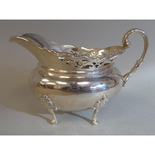 23 - A three piece silver tea set of oval, bulbous form with angled, pierced upstand rims, comprising a t... 