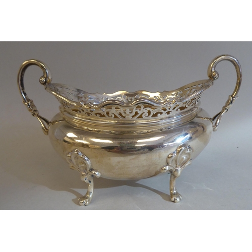 23 - A three piece silver tea set of oval, bulbous form with angled, pierced upstand rims, comprising a t... 