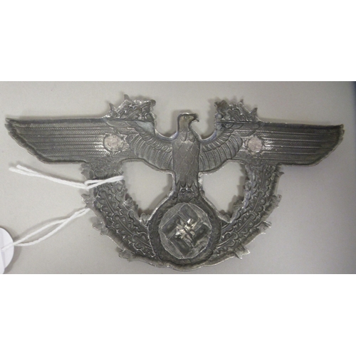 237 - A Third Reich era, cast alloy emblem, featuring a spreadeagle, over an oak leaf pattern swastika(Ple... 