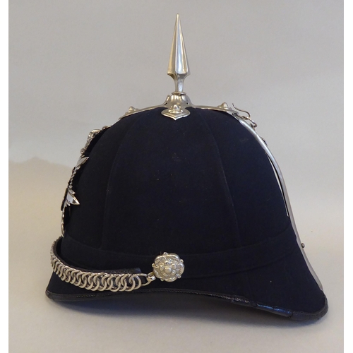 24 - A University of Cambridge black fabric covered helmet with a spike and chinstrap  bears a Pipe &... 