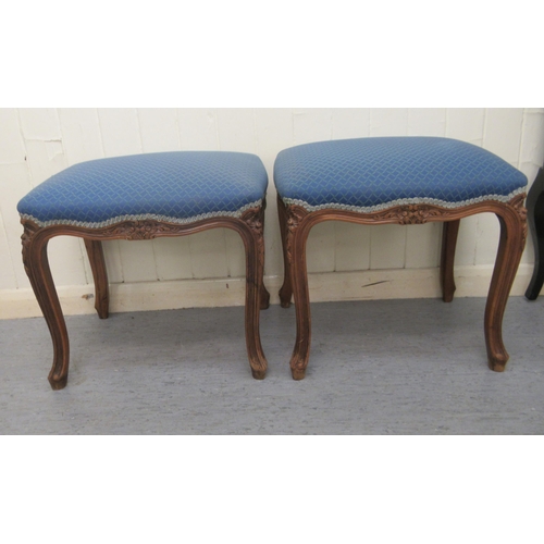 251 - A pair of 20thC carved and moulded mahogany framed and upholstered stools of serpentine outline, the... 