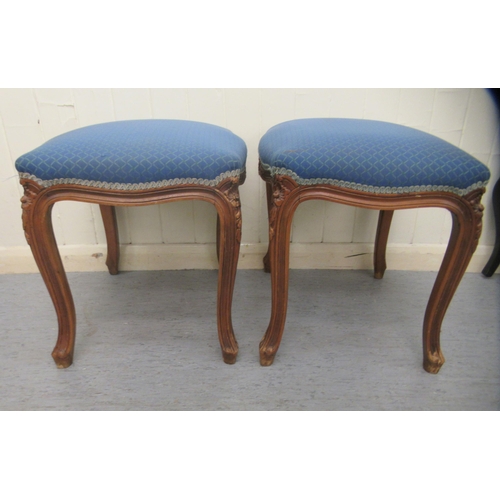 251 - A pair of 20thC carved and moulded mahogany framed and upholstered stools of serpentine outline, the... 