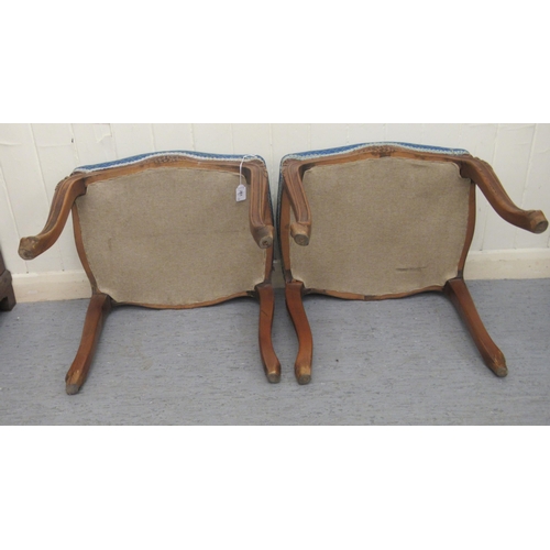 251 - A pair of 20thC carved and moulded mahogany framed and upholstered stools of serpentine outline, the... 