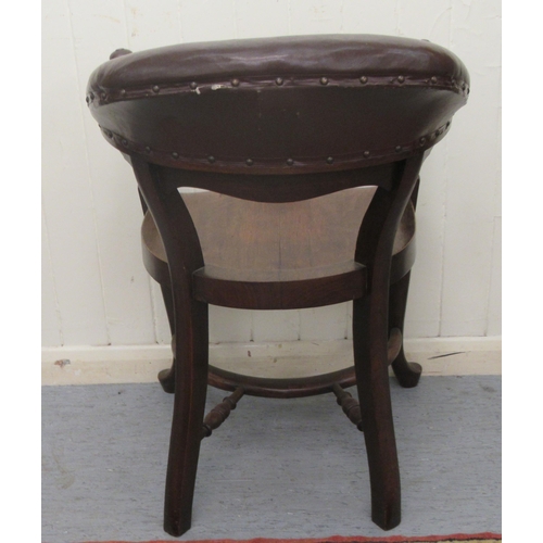 253 - A late 19th/early 20thC mahogany framed horseshoe shape desk chair, the stud upholstered rexine cres... 