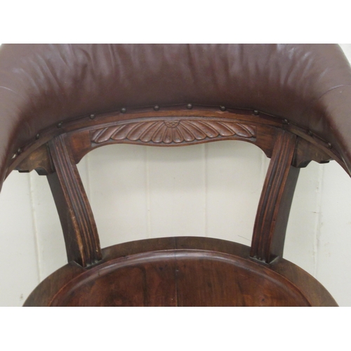 253 - A late 19th/early 20thC mahogany framed horseshoe shape desk chair, the stud upholstered rexine cres... 