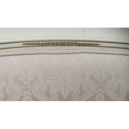 258 - A late 19thC style Continental cream painted and gilded showwood framed settee with a low arch back ... 