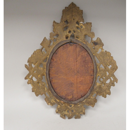 277 - A 19thC oval mirror, set in an ornately, bead carved and floral decorated, giltwood frame  18